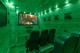 Private cabin theater with big screen, recliner seating, and mood lighting.