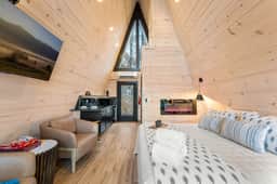 Stylish A-frame: cozy bed, kitchenette, fireplace & forest views