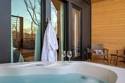 Private deck with hot tub, forest views, and cozy seating—pure relaxation.