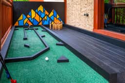 Playful outdoor mini golf deck with colorful mural and games