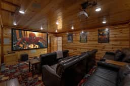 Cozy wood-paneled home theater with big screen and plush recliner seating