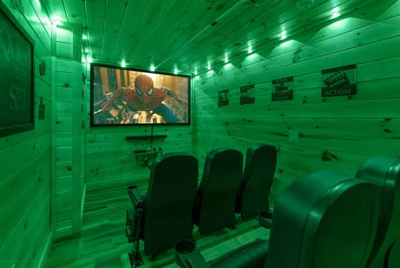 Private cabin theater with big screen, recliner seating, and mood lighting.