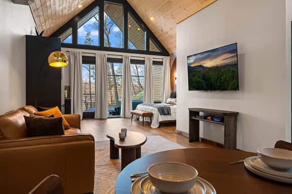 A-frame retreat with vaulted ceilings, huge windows, and balcony views